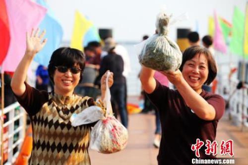 資料圖：兩位女遊客手舉獲贈的陽澄湖大閘蟹，開心不已。 　李克祥 攝