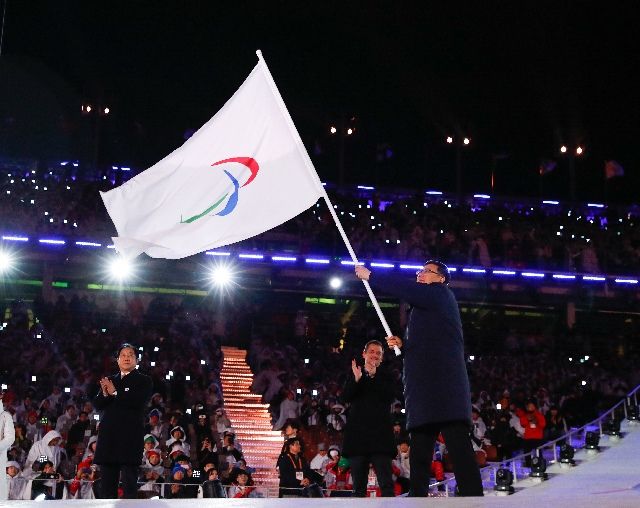 北京市市長陳吉寧（右）在閉幕式上揮舞國際殘奧委會會旗