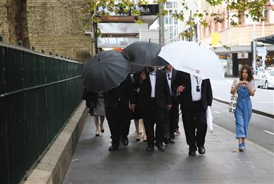 高雲翔的妻子董璿昨天參加庭審，躲避在保鏢的黑傘之後。 圖/視覺中國