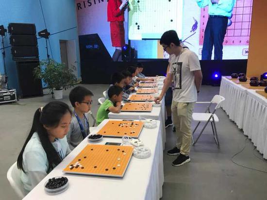 中國棋院杭州分院的職業棋手正在與小棋手下指導棋