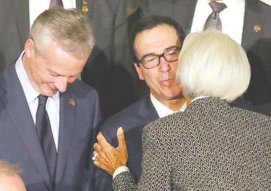 圖為7月21日，在阿根廷布宜諾斯艾利斯，IMF總裁拉加德（右）和美國財政部長姆努欽（中）行吻面禮（圖文綜合央視財經、新華社）