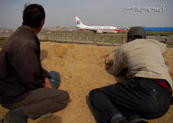 照片為昆明機場外農民工看飛機起降